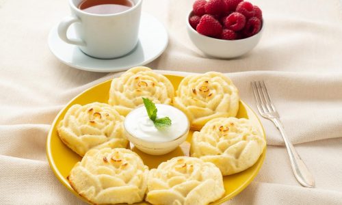 diet-cheese-pancakes-rose-shape-on-yellow-plate-with-tea-raspberry-on-textile-linen-napkin.jpg